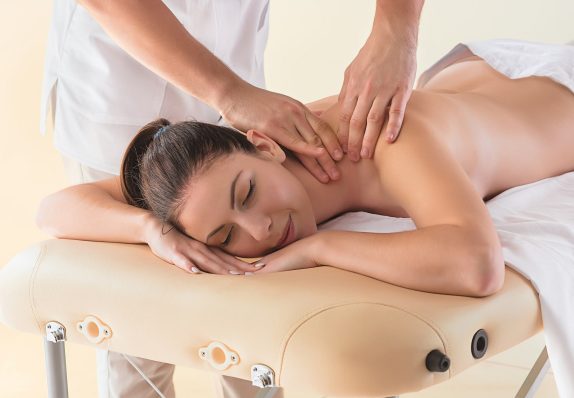 The picture of beautiful woman in massage salon The picture of beautiful woman in massage salon and male hands close up